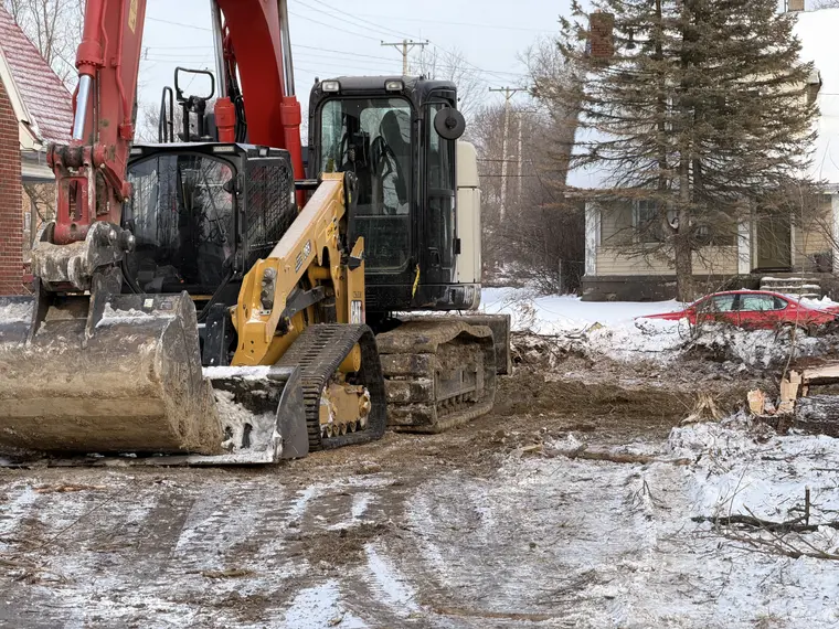 Skid steer and excavator working a site in winter